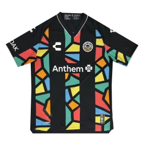 The Unisex Oakland Roots SC 2025 First Kit features a black V-neck soccer jersey with multicolored mosaic patterns on the front and sleeves, white "C" and emblem logos, and "Anthem" across the chest, reflecting Oakland Roots SC's inclu